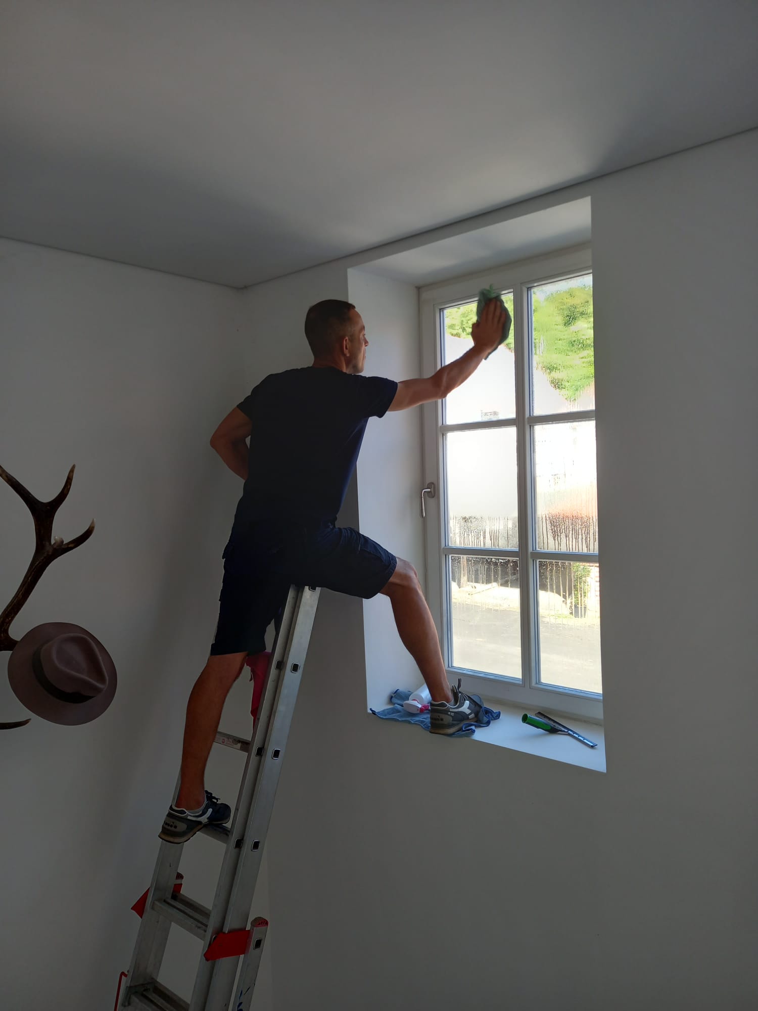 Fensterreinigung im Innenbereich von der Leiter aus