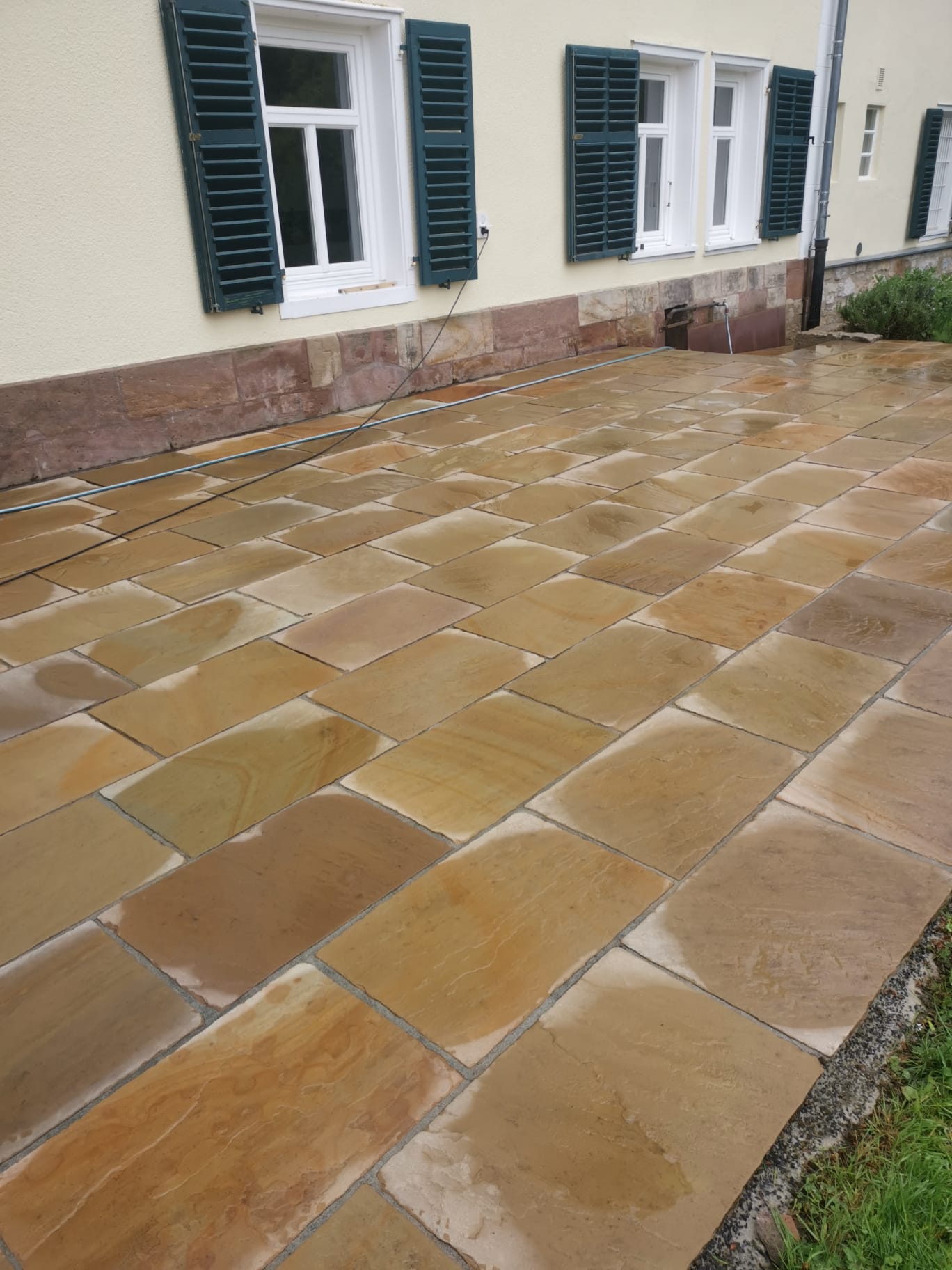 Frisch gereinigte Natursteinterrasse an einem Wohnhaus