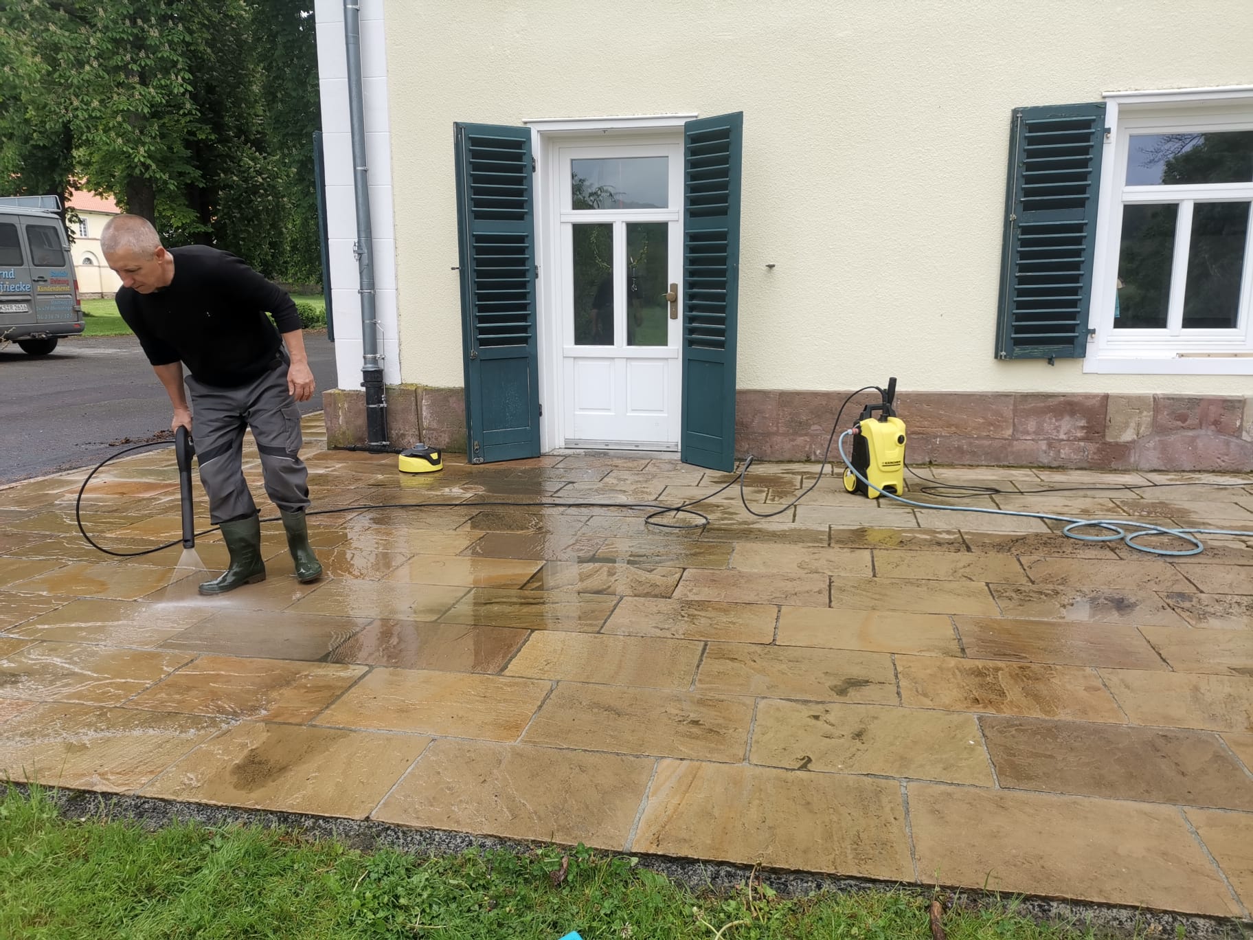 Hochdruckreinigung der Terrassenfläche vor einem Wohnhaus